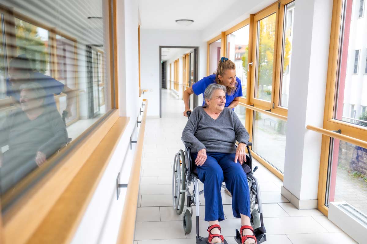 Pflegerin mit Frau im Rollstuhl